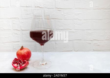 Granatapfel Wein in ein Glas Wein auf neutralem Hintergrund Stockfoto