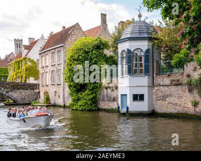 Touristische Bootsfahrt auf dem Kanal Groenerei in der historischen Altstadt von Brügge, Belgien. Stockfoto