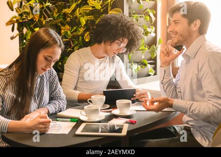 Chef und Mitarbeiter Lücke. Team Leader am Telefon sprechen, während andere Arbeiten an Mittagspause im Cafe Stockfoto