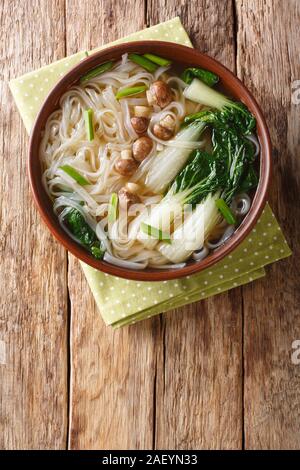Würziger Reis Nudelsuppe mit Pilzen, Asiatische Gewürze und Bok choy closeup in einer Schüssel auf den Tisch. Vertikal oben Ansicht von oben Stockfoto