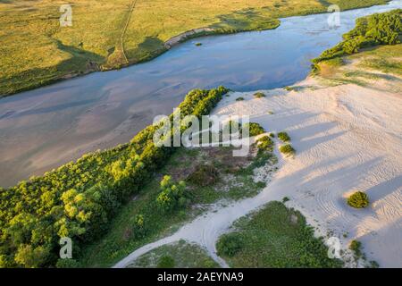 Flach und weit Dismal Fluss fließt durch Nebraska Sandhills bei Nebraska National Forest, Luftaufnahme Sommer Landschaft mit sandigen off road spielen eine Stockfoto