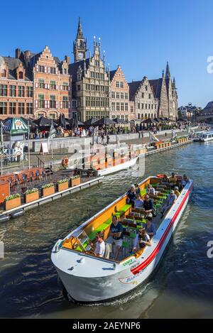 Schiff mit Touristen auf dem Fluss Lys mit Blick über guildhalls an der Graslei / Gras Lane in der Stadt Gent/Gent, Flandern, Belgien Stockfoto