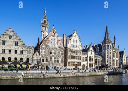 Touristen am Kai entlang des Flusses Lys/Leie und Blick auf mittelalterliche guildhalls an der Graslei / Gras Lane in der Stadt Gent, Flandern, Belgien Stockfoto