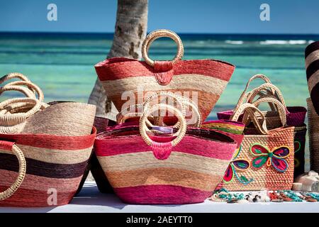 Verkaufen Sie Taschen am Strand gegen das azurblaue Wasser der Karibik in Mahahual, Quintana Roo, Mexiko. Stockfoto
