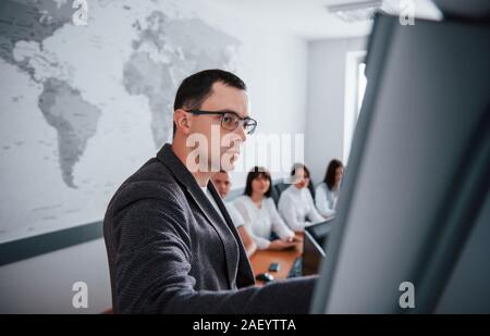 Ein Blick auf diese Grafik. Gruppe von Personen bei Business Konferenz in modernen Unterricht tagsüber Stockfoto
