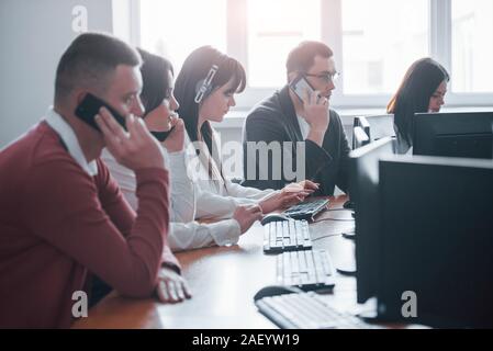 Ich höre Sie, Was für ein Problem haben Sie. Junge Menschen im Call Center arbeiten. Neue Geschäfte kommen Stockfoto