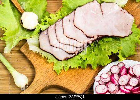 Gesundes Frühstück mit Fleisch, Schinken und Gemüse auf Tisch Stockfoto