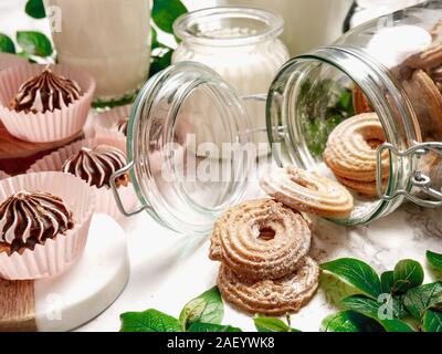 Leichtes Bier in einem kleinen Becher auf einem Holzkoffer in einer Anordnung mit frischem Hopfen. Stockfoto