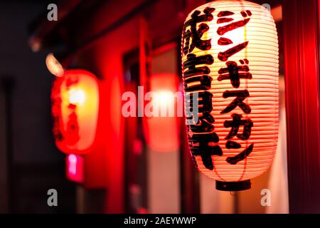 Kyoto, Japan - April 9, 2019: Allee Straße in Gion Distrikt nachts mit Nahaufnahme des beleuchteten rotes Papier Lampe und bokeh Hintergrund Eingang resta Stockfoto