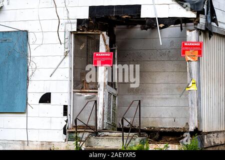 Atlanta, USA - 21. April 2018: die alten, verlassenen verwitterten weißes Holzhaus mit Eingang und roten Hinweis Schilder Warnung von Fire Marshal Stockfoto