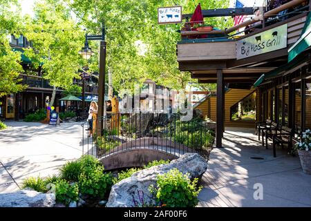 Aspen, USA - Juni 24, 2019: Snowmass Village Stadt in Kolorado Innenstadt mit Big hoss Grill Restaurant und kleinem Garten Park mit Brücke Stockfoto