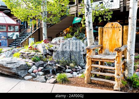 Aspen, USA - Juni 24, 2019: Snowmass Village Stadt in Kolorado Innenstadt mit großen hölzernen Stuhl von kleinen Garten Park Stockfoto