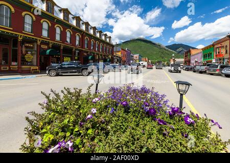 Silverton, USA - 14. August 2019: Kleine Stadt in Colorado Nahaufnahme von Blumen mit Stadt Hauptstraße Weitwinkel von Straße durch die historische Architektur speichert s Stockfoto