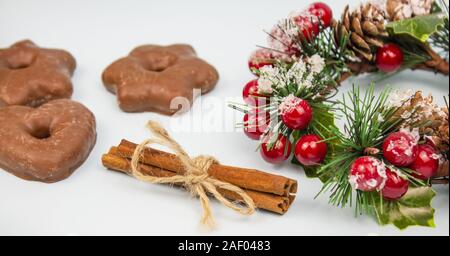 Weihnachten Komposition mit Schokolade Lebkuchen cookies und Zimt, Weihnachten Kranz und Essstäbchen auf einem hellen Hintergrund. Zimt. Banner platzieren. Stockfoto