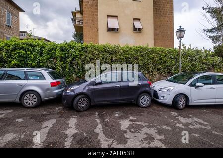Ein schwarzes Auto zwischen zwei othe Autos in einen Parkplatz am Straßenrand blockiert Stockfoto