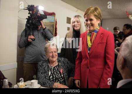 Glasgow, UK, 11. Dezember 2019. Nicola Sturgeon, Leiter der Scottish National Party, Erster Minister Schottlands, verbindet Amy Callaghan, SNP-Kandidat für den Wahlkreis East Dunbartonshire, wie sie in einem Rentner Weihnachtsessen Pop, in Glasgow, am Tag vor der Nation geht an den Umfragen im Jahr 2019 allgemeine Wahlen. Quelle: Jeremy Sutton-Hibbert / alamy Leben Nachrichten. Stockfoto