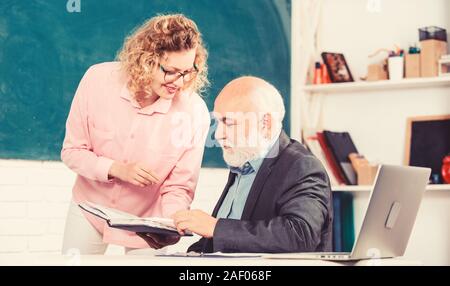 Schüler, Lehrer über Aufgabe. Lehrer und Schüler auf der Suche nach Buch. Schwierig zu erklären. Lösen von mathematischen Aufgaben. Buchen Sie Quelle wissen. School Buch Konzept. Helfen Sie mir bitte. Hausaufgaben prüfen. Stockfoto