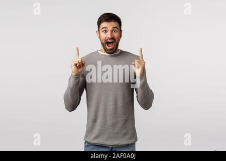 Glück, overjoy und lassen Sie sich überraschen. Erstaunt, sprachlos und wunderte sich, bärtigen Freund im grauen pullover, siehe etwas Erstaunliches und Unglaubliches Stockfoto