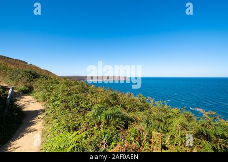 Fahrt auf dem GR34 in der Bretagne mit weit entfernten Kap Frehel und seinem Leuchtturm Stockfoto