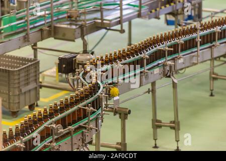 Die Bierherstellung. Getränkeabfüllung. Plastikflaschen in der Fabrik. Förderband Bierflaschen. Stockfoto