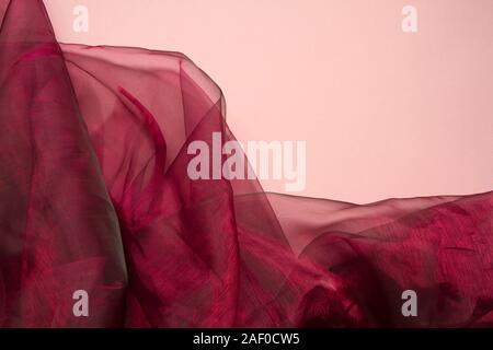 Falds von rotem Stoff organza Tüll oder auf eine Koralle Farbe Hintergrund, selektiver Fokus Stockfoto