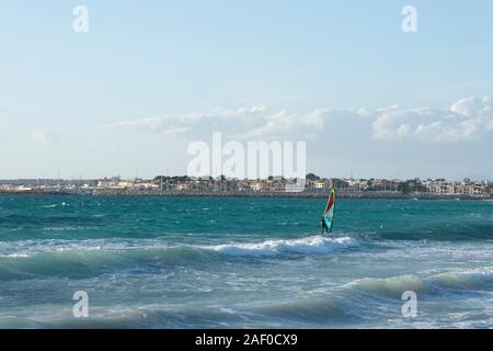 Ses Covetes/Colonia de San Jordi, Campos, Mallorca, Spanien - 09. Dezember 2019: mit Wellen und ein Mann genießen und üben Windsurfen Seascape Stockfoto