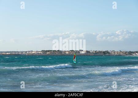 Ses Covetes/Colonia de San Jordi, Campos, Mallorca, Spanien - 09. Dezember 2019: mit Wellen und ein Mann genießen und üben Windsurfen Seascape Stockfoto