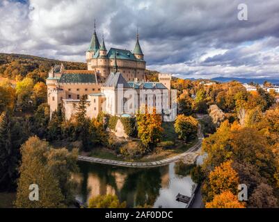 Luftaufnahme von Bojnice mittelalterlichen Burg, UNESCO-Kulturerbe in der Slowakei. Romantisches Schloss mit Farben des Herbstes mit der Gotik und der Renaissance Element umgeben Stockfoto