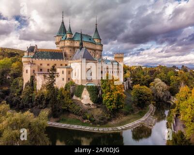 Luftaufnahme von Bojnice mittelalterlichen Burg, UNESCO-Kulturerbe in der Slowakei. Romantisches Schloss mit Farben des Herbstes mit der Gotik und der Renaissance Element umgeben Stockfoto