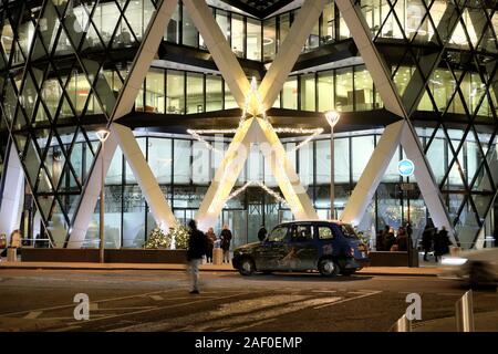 Weihnachtsdekoration Leute Taxi vor dem Eingang zum 30 Saint Mary Axe Wolkenkratzer Gebäude Nacht Finanzviertel City of London UK KATHY DEWITT Stockfoto