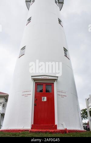 Ältester noch betriebsfähiger Leuchtturm NZ aus Gusseisen, weiß lackiert mit roter Tür. Erbaut 1864 eröffnet 1865. Solarbetrieben. Hauraki Golf, Auckland. Stockfoto