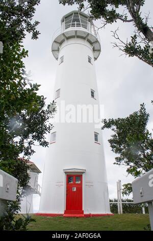 Ältester noch betriebsfähiger Leuchtturm NZ aus Gusseisen, weiß lackiert mit roter Tür. Erbaut 1864 eröffnet 1865. Solarbetrieben. Hauraki Golf, Auckland. Stockfoto