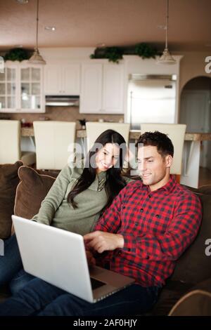 Paar mit Laptop in Ihrem Wohnzimmer Stockfoto