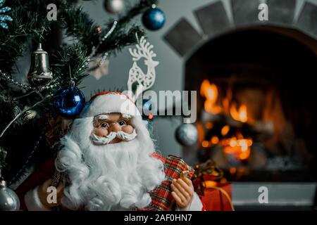 Santa Claus Geschenke für Weihnachten und ein Rest durch den Kamin. Home Dekoration. Stockfoto