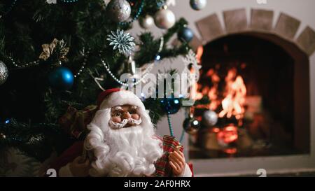 Santa Claus Geschenke für Weihnachten und ein Rest durch den Kamin. Home Dekoration. Stockfoto