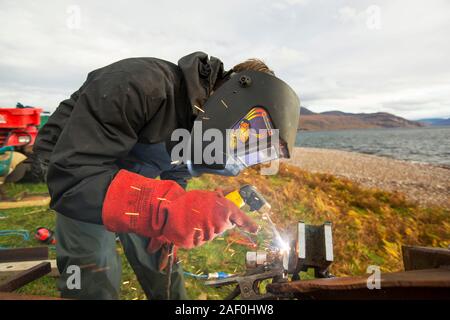 Hugh Piggott, Wartungsarbeiten an seinem Haus aus Windenergieanlagen in Scoraig, im NW von Schottland, einer der entlegensten Gemeinschaften auf dem Festland Großbritannien, home Stockfoto