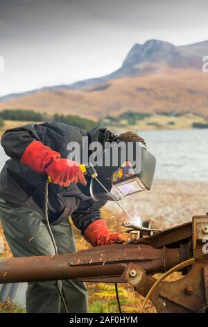 Hugh Piggott, Wartungsarbeiten an seinem Haus aus Windenergieanlagen in Scoraig, im NW von Schottland, einer der entlegensten Gemeinschaften auf dem Festland Großbritannien, home Stockfoto