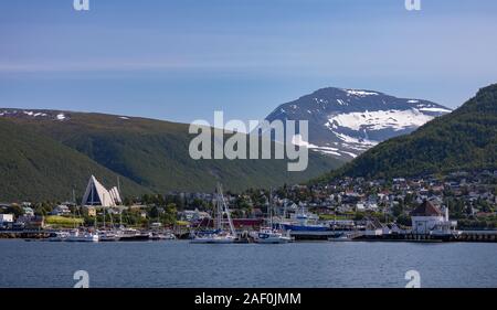 TROMSØ, NORWEGEN - am Wasser, in den Bergen, und Tromsdalen Kirche auf der linken Seite. Auch als die Eismeerkathedrale bekannt. Stockfoto