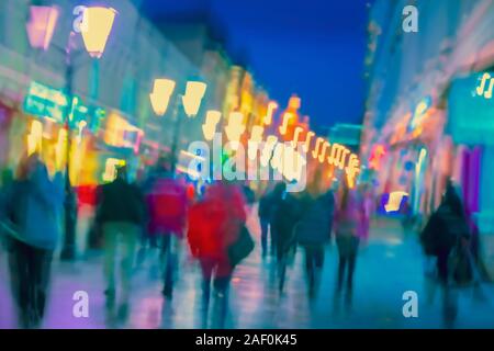 Helle unscharfe moderne Stadt in der Nacht, defokussierten Urban bokeh City Lights, Silhouetten der wenige Menschen. Abstrakte bunten Hintergrund Stockfoto