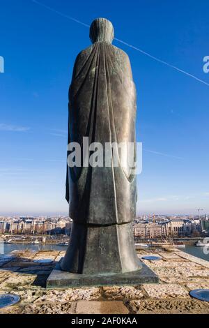 4 Meter hohe Bronzestatue der Jungfrau Maria mit Jesus auf den Wänden der Budaer Burg mit Blick auf die Donau. Winter in Budapest, Ungarn. Stockfoto