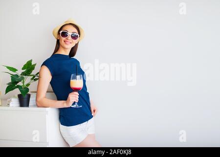 Ferienhäuser. Frau, die Vorbereitung für die Erholung. Junge schöne Mädchen sitzt auf dem Bett. Porträt eines lächelnden Frau. Glückliches Mädchen geht auf Urlaub Stockfoto