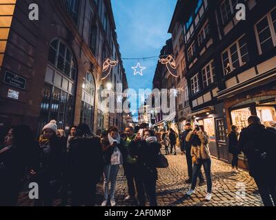 Straßburg, Frankreich - Dec 24, 2018: Weitwinkelaufnahme der großen Gruppe von Freunden Touristen wandern Fotos der legendären Weihnachten neues Jahr Dekorationen auf der Fußgängerzone Stockfoto