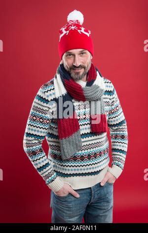 Express Positivität. männliche Fashion Kollektion. Reifer mann Komfort genießen können. Weihnachten Zeit. In neuen Jahr Stimmung. Happy bärtiger Mann roten Hintergrund. Gestrickte Zubehör. kaltem Wetter Trends. Stockfoto