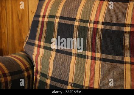 Plaid Couch mit Wand im Hintergrund Stockfoto