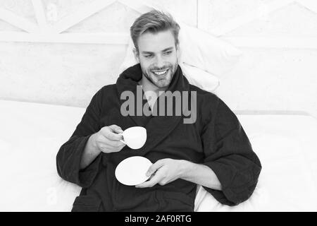 Gourmet Espresso. Kaffee am Morgen genießen. Gerne morgen. Schöner Mann trinken Kaffee am Morgen. Happy bärtiger Mann im Bett. Gute Laune. Ab Tag mit guten Kaffee. Entspannt zu Hause. Angenehme Momente. Stockfoto