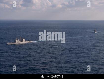 191129-N-OI 558-1795 EAST CHINA SEA (Nov. 29, 2019) Die Ticonderoga-Klasse geführte-missile Cruiser USS Shiloh (CG67), links, Segel, die sich in der Ausbildung mit der Arleigh-Burke-Klasse geführte Anti-raketen-Zerstörer USS Barry (DDG52) während einer Manövrieren übung Oberfläche Action Group Aktivitäten zu unterstützen. Silo ist Vorwärts - in die USA 7 Flotte Bereich für Maßnahmen zur Erhöhung der Sicherheit und Stabilität in der indopazifischen Region bereitgestellt. (U.S. Marine Foto von Mass Communication Specialist 3. Klasse Chanel L. Turner) Stockfoto