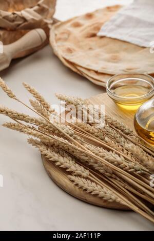 Lavash Brot bedeckt mit weißen Handtuch in der Nähe von Rolling Pin und Schneidbrett mit Spikes und Öl Stockfoto