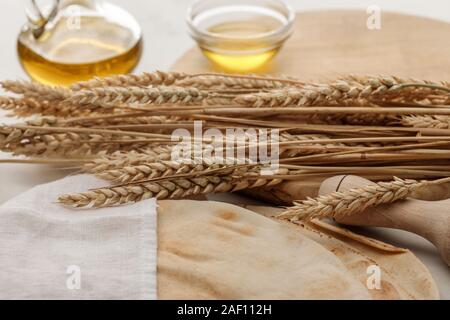 Lavash Brot bedeckt mit weißen Handtuch in der Nähe von Rolling Pin und Schneidbrett mit Spikes und Olivenöl Stockfoto