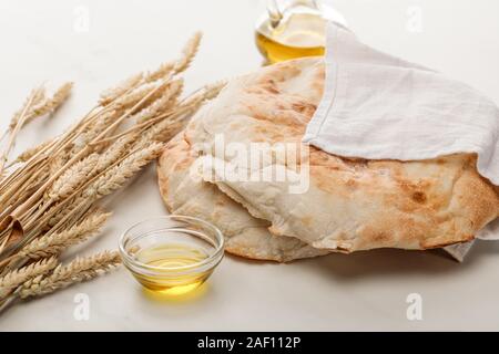 Lavash Brot mit Handtuch in der Nähe von Spitzen und Öl auf Marmor Oberfläche beschichtet Stockfoto