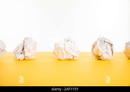 Zerknittertes Papier auf gelbe Oberfläche isoliert auf weißem Stockfoto